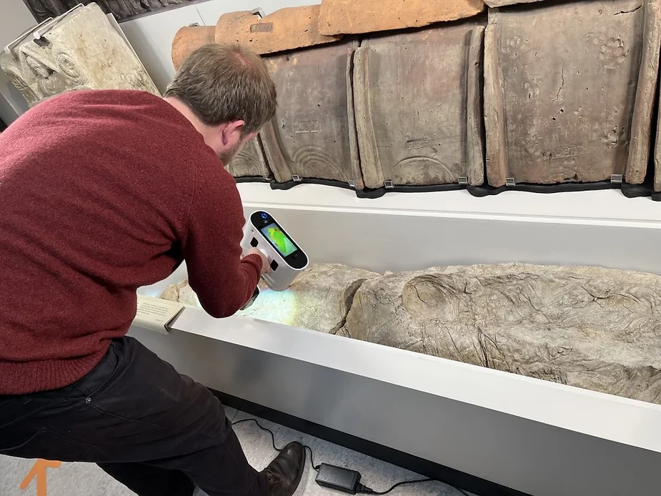 Un archéologue examine une dépouille Romaine à l'aide d'un scan 3D